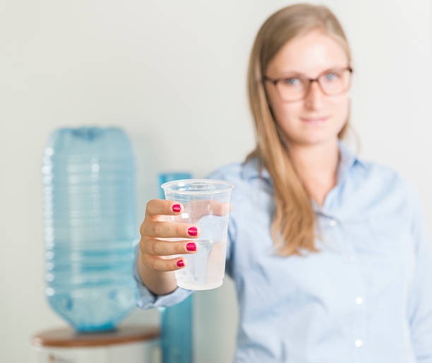 istock Businesswoman having drink from Water cooler. 179387440
