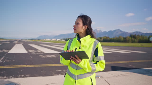Asian Female Airfield Operations Officer Using A Digital Tablet