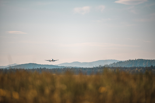 Commercial airplane landing at the airport. Closing in to the runway. Beautiful Alps in the background.