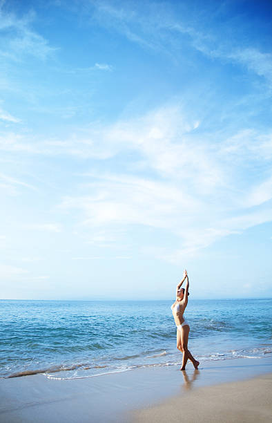 istock Young woman on a beach doing yoga 179394479