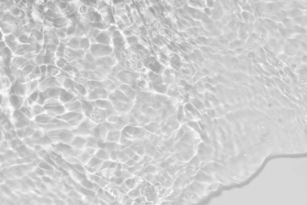 istock White water with ripples on the surface. Defocus blurred transparent white colored clear calm water surface texture with splashes and bubbles. Water waves with shining pattern texture background. 1793958669