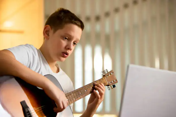 Photo of Elevating Harmonies: Teen in White T-Shirt Crafts Melodic Mastery