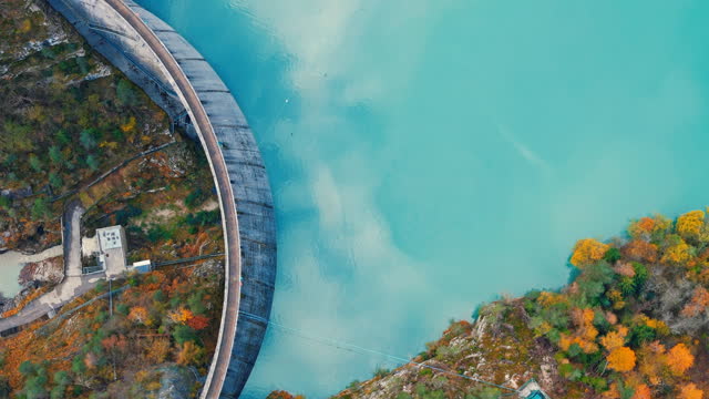 AERIAL Directly Above Shot of Drone Flying Over Curve Dam and Turquoise Lake in Autumn