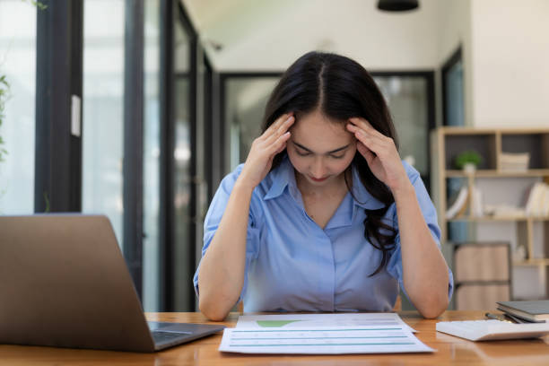 istock Tired Asian businessman has a headache from paperwork and looking at the computer screen a lot at the office, feeling sick at work 1794074955