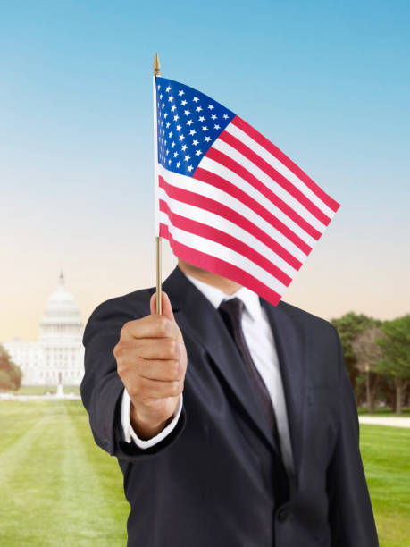 USA  Flag Businessman holding a USA  flag in front of Capitol building in Washington DC celebrate in the park canberra stock pictures, royalty-free photos & images