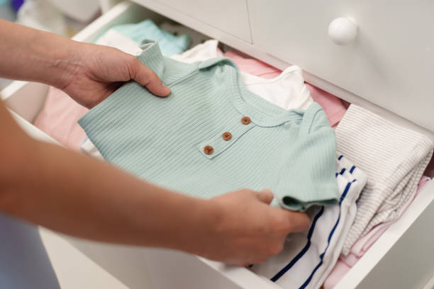 istock mother taking baby clothes from open cabinet drawer 1794140623