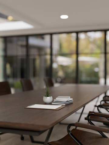 Close-up image of a hardwood meeting table in a modern spacious meeting room. Business workspace, corporate job, office building. 3d render, 3d illustration