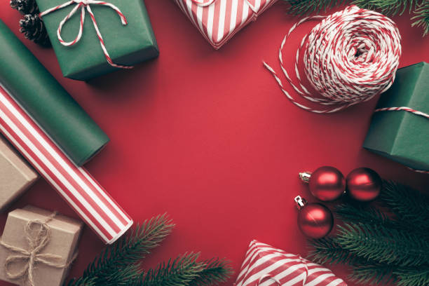 istock Christmas gift boxes with paper's rools and decorations on red background. 1794165843