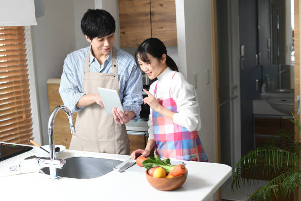istock An Asian couple cooks in their home kitchen while checking recipes on a tablet device. 1794172778