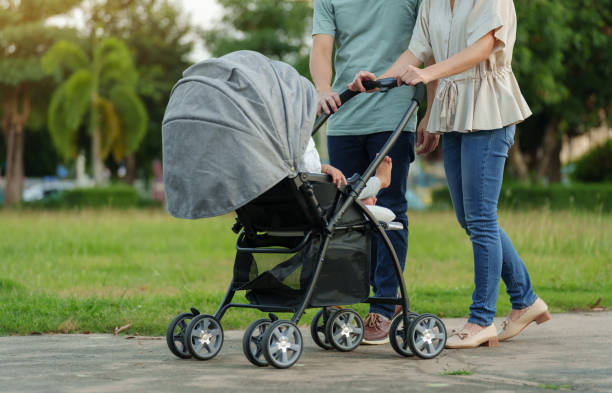 istock parent (father and mother) pushing infant baby stroller and walking in park 1794173830