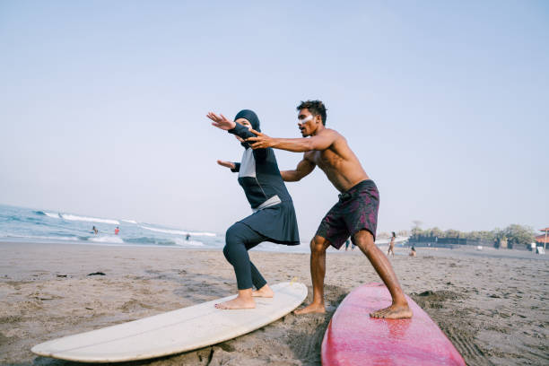 istock Hijab Surfer Learning How to Surf with Her Instructor 1794177532