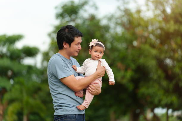 istock father holding and talking with infant baby in park 1794196583