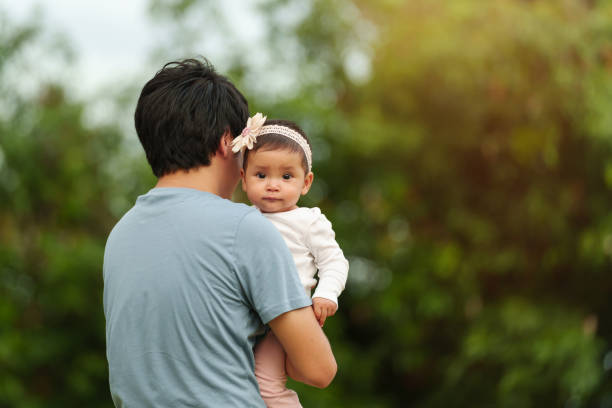 istock father holding infant baby in park 1794196584