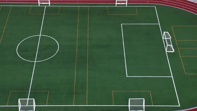 Empty Multipurpose Football and Athletics Training Field with Synthetic Grass