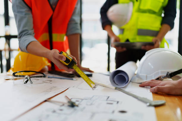 istock engineers discuss building on blueprint drawing, design building Project in office. 1794221613