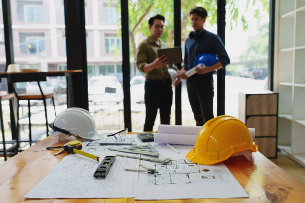 istock engineers discuss building on blueprint drawing, design building Project in office. 1794222146
