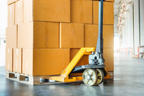 istock Package Boxes Stack on Pallet and Hand Pallet Truck. Cartons, Cardboard Boxes. Storehouse, Distribution, Supply Chain. Supplies Warehouse Shipping. 1794230021