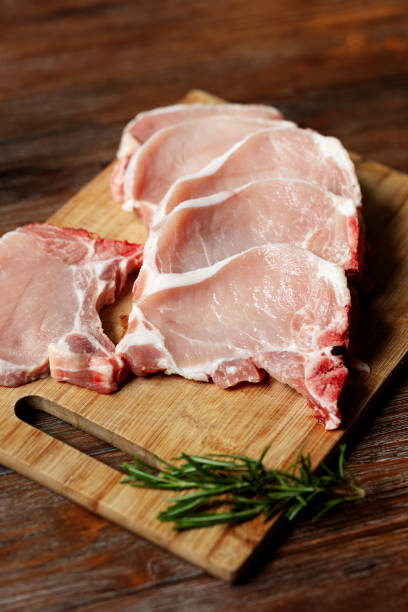 Raw pork steaks on a bone on a cutting board