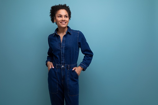 young confident hispanic business woman dressed in blue denim suit over isolated background.