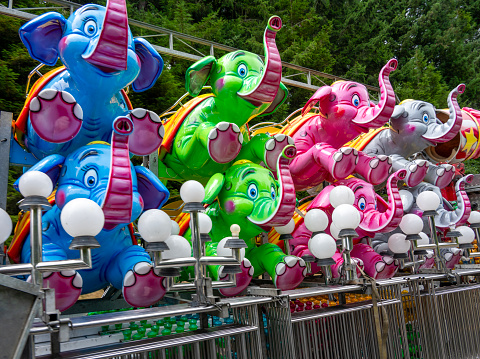 Rows of happy elephants from a carnival ride moving to a new location on a semi truck.