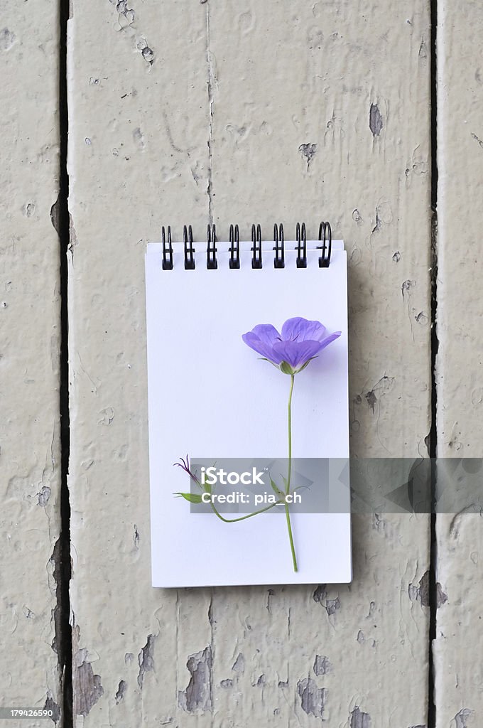 Bloco de papel em branco e roxo flores sobre fundo de prancha de madeira rústica - Foto de stock de Caderno de Anotação royalty-free