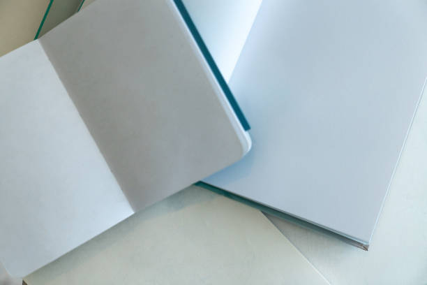 istock Open notebook and books on white blank paper, flat lay, mock up. 1794291308