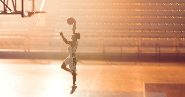 istock Young man playing basketball on court 1794334549