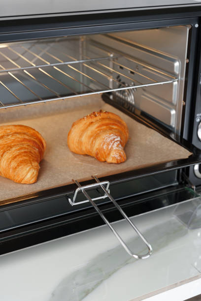 istock Modern mini electric oven with freshly baked croissants in kitchen 1794343753