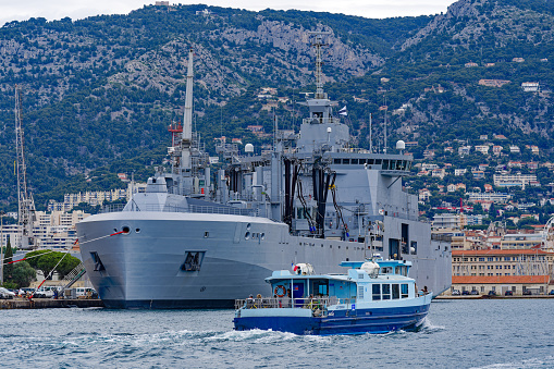 Moored modern supply and tanker warship Jacques Chevallier A-725 at French Navy Naval Base at City of Toulon on a cloudy late spring day. Photo taken June 9th, 2023, Toulon, France.