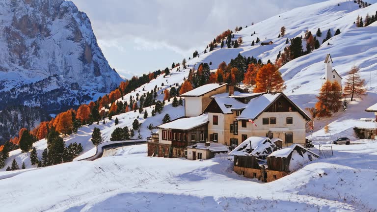 AERIAL Drone Shot of Mountain Lodge and Country Road on Snow Covered Landscape in Dolomites, Italy