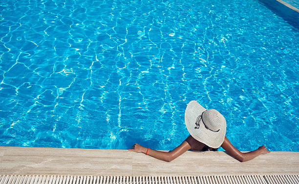 istock Young woman relaxing by the pool 179438031