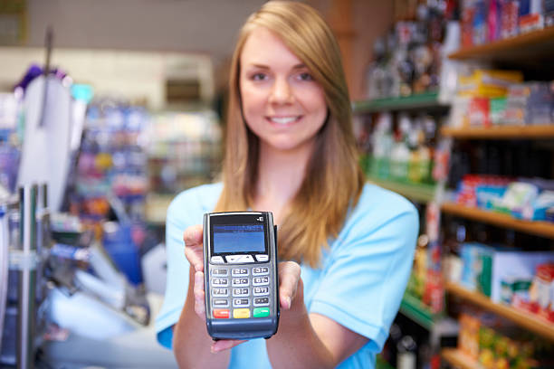 istock Female Sales Assistant Holding Credit Card Machine 179438419