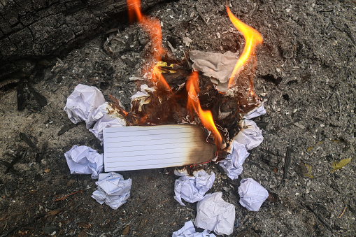 Burning paper on the ground. Close up paper burning in flame
