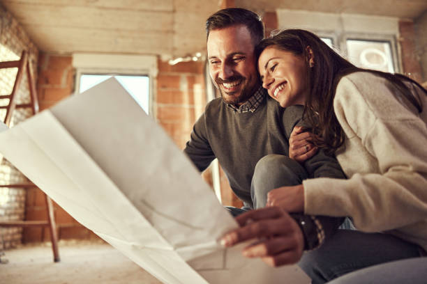 istock Happy couple analyzing plans at their renovating apartment. 1794411626