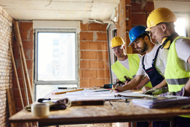 istock Team of manual workers examining housing project while working at construction site. 1794418424