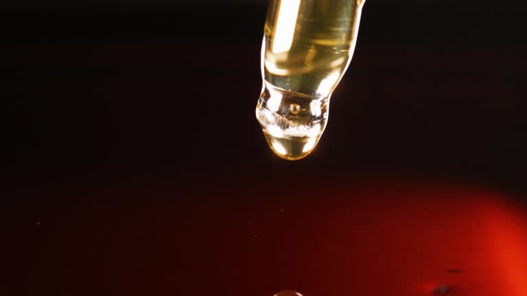 Clear yellow-orange liquid is dripping from pipette 4k movie