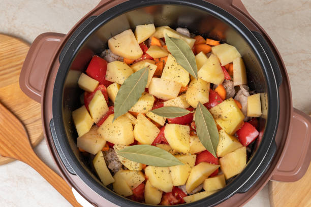 istock Modern, light multi cooker with products. Cooking stewed potatoes with meat in multicooker. Close-up top view of multi cooker with vegetables and meat. 1794447941