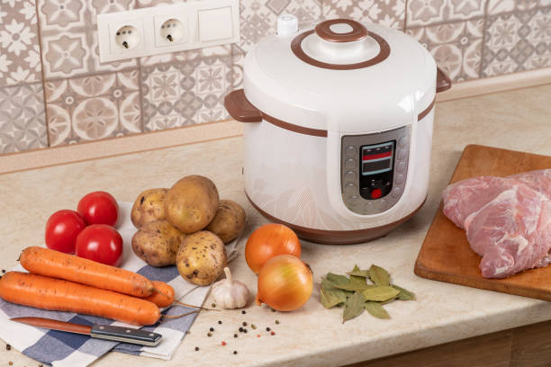 istock Modern, light multi cooker and products on table in kitchen. Cooking stewed potatoes with meat in multicooker. 1794447942