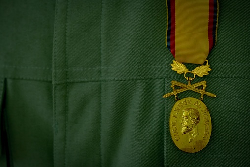 Timisoara, Romania – November 01, 2023: A closeup of a military uniform adorned with a gold medal of Carol I, the first monarch of Romania.