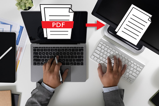 PDF button on screen Laptop computer converting process of document to another format Convert PDF files with online programs.