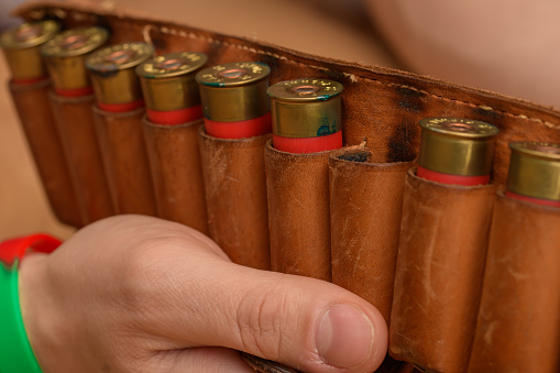 Leather case for cartridges for hunting weapons held in hands closeup