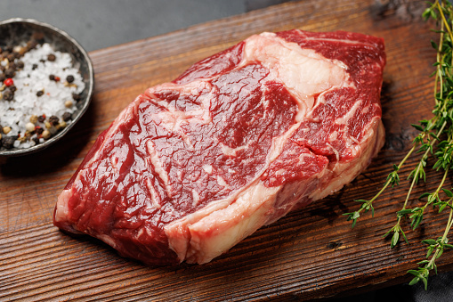 Raw beef ribeye steak, fresh and ready for cooking, promising a mouthwatering culinary experience