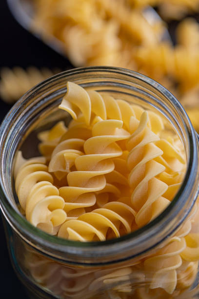 istock Uncooked fusilli pasta. Uncooked italian pasta in jar. 1794536434