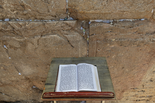 A siddur or Jewish prayer book is open to the Hebrew text of the Song of Songs on a book stand in front of the Western Wall in Jerusalem.
