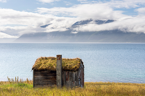 An Old Turf Roofed Building by the Sea on a sunny summer day in the Lyngen Alps in Northern Norway