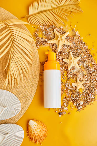 istock Flat lay, top view Sunscreen tube mockup with shells, sand yellow background, summer vacations and spf uv-protecting skin care concept 1794548022