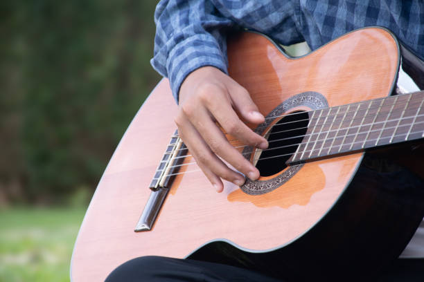 istock Closeup hands playing acoustic guitar. 1794564281