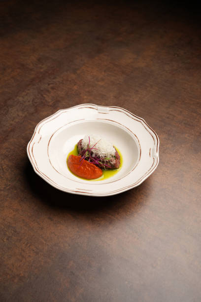 istock Beef tartare with tomato sauce served on a white plate 1794571664