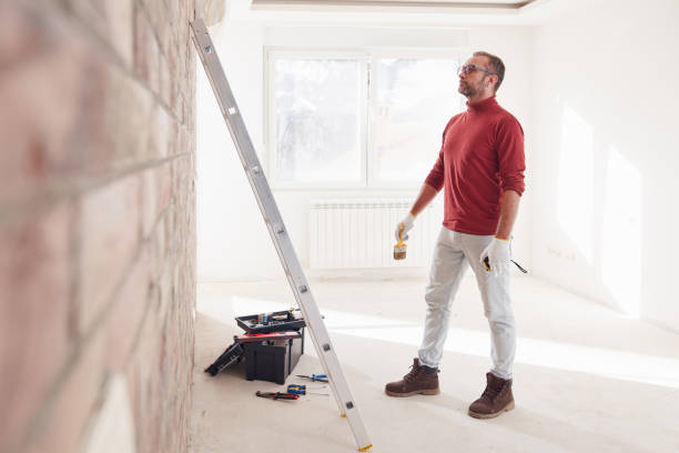 istock Handyman electrician with ladders working in a new home interior. 1794582972
