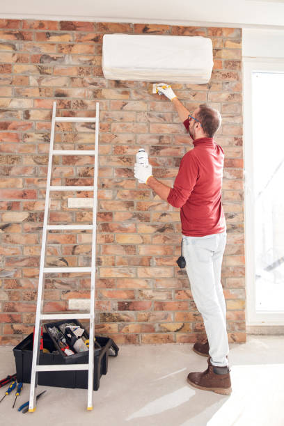 istock Handyman electrician with ladders working in a new home interior. 1794584576